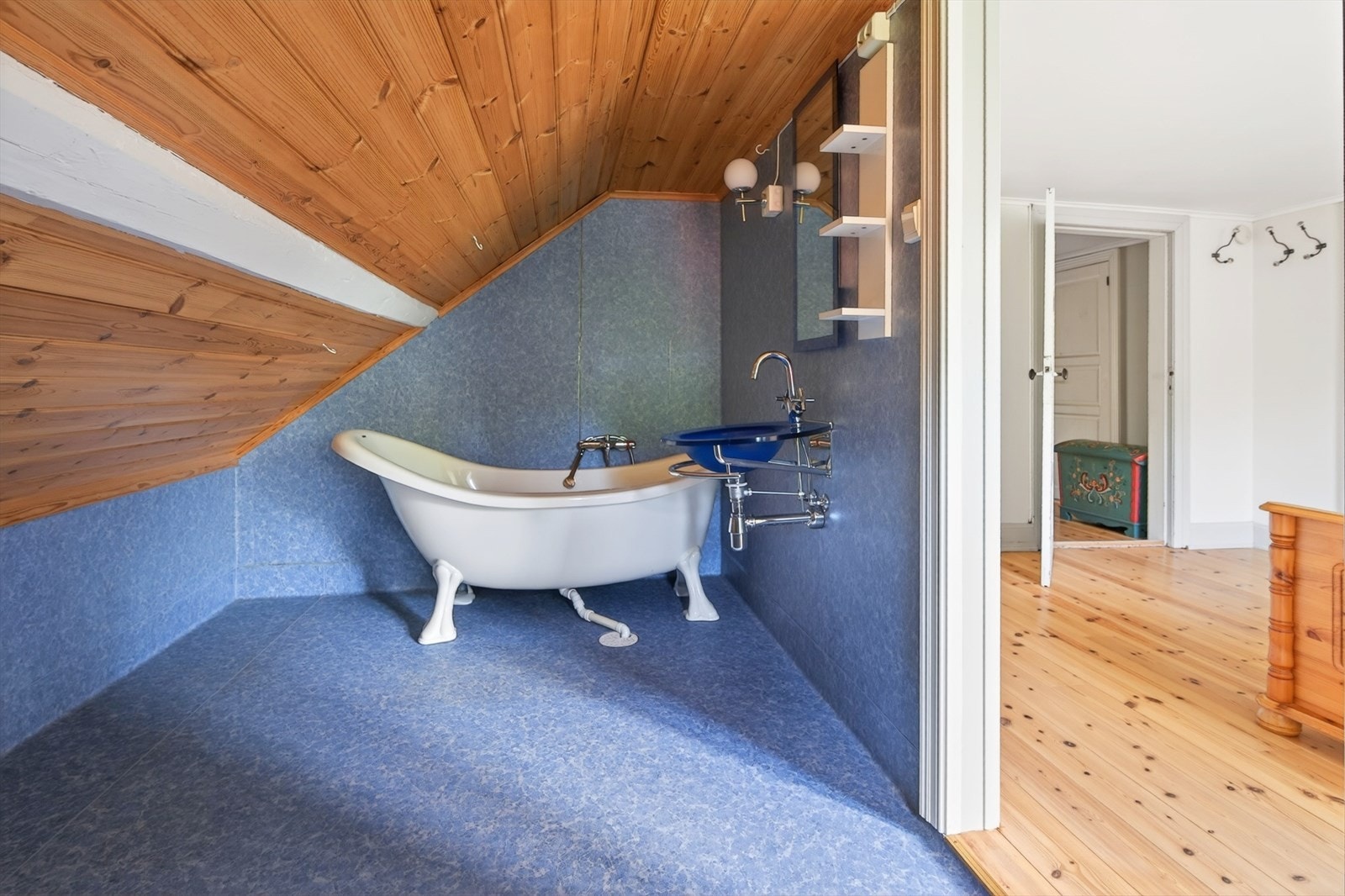 Badet på loftet er utstyrt med badekar og har vinylbelegg på gulv og vegger. Galleribilde