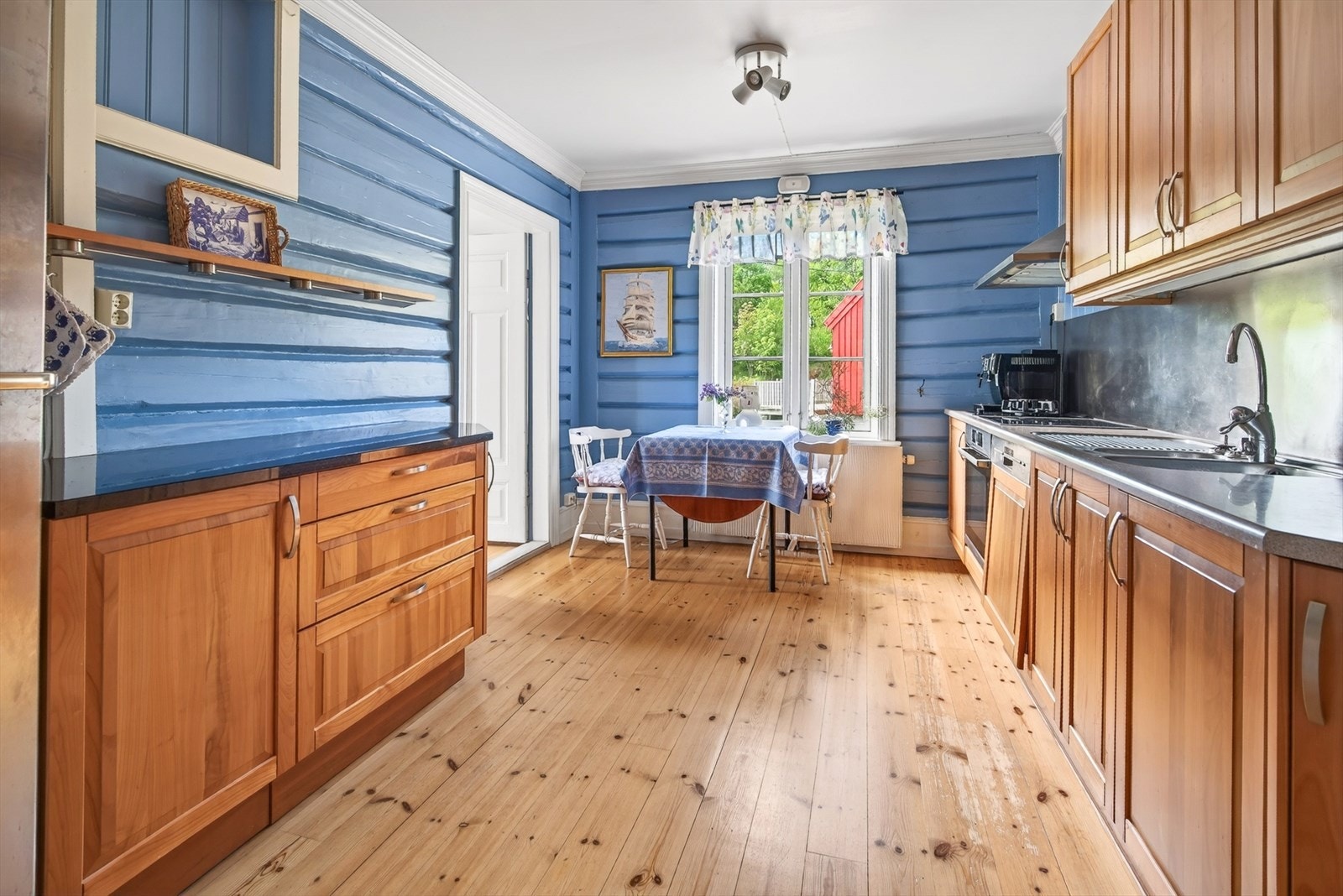 Kjøkkenet i hovedhuset har innredning med profilerte fronter og benkeplate i laminat og stein. Galleribilde