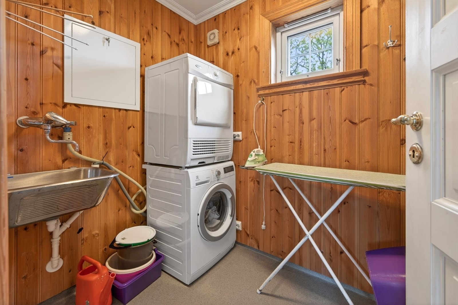 Praktisk vaskerom med elektriske varmekabler i gulvet, utslagsvask og opplegg for vaskemaskin. Galleribilde