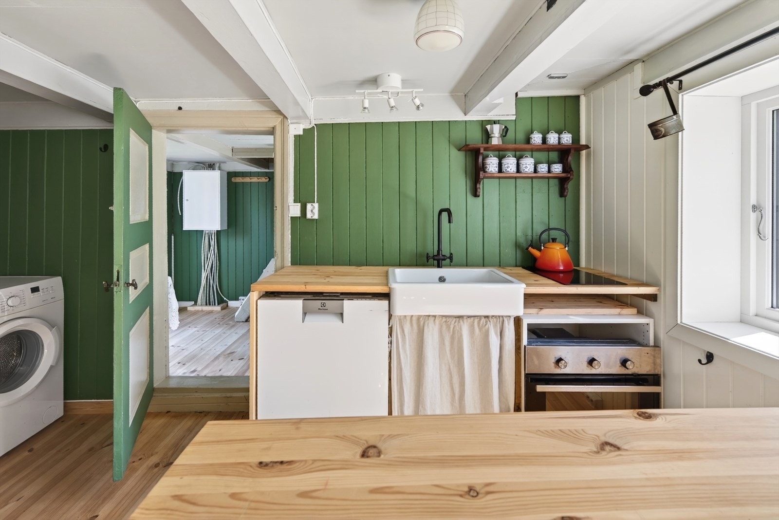 Kjøkkenet i gjestehuset har innredning med benkeplate i heltre. Galleribilde