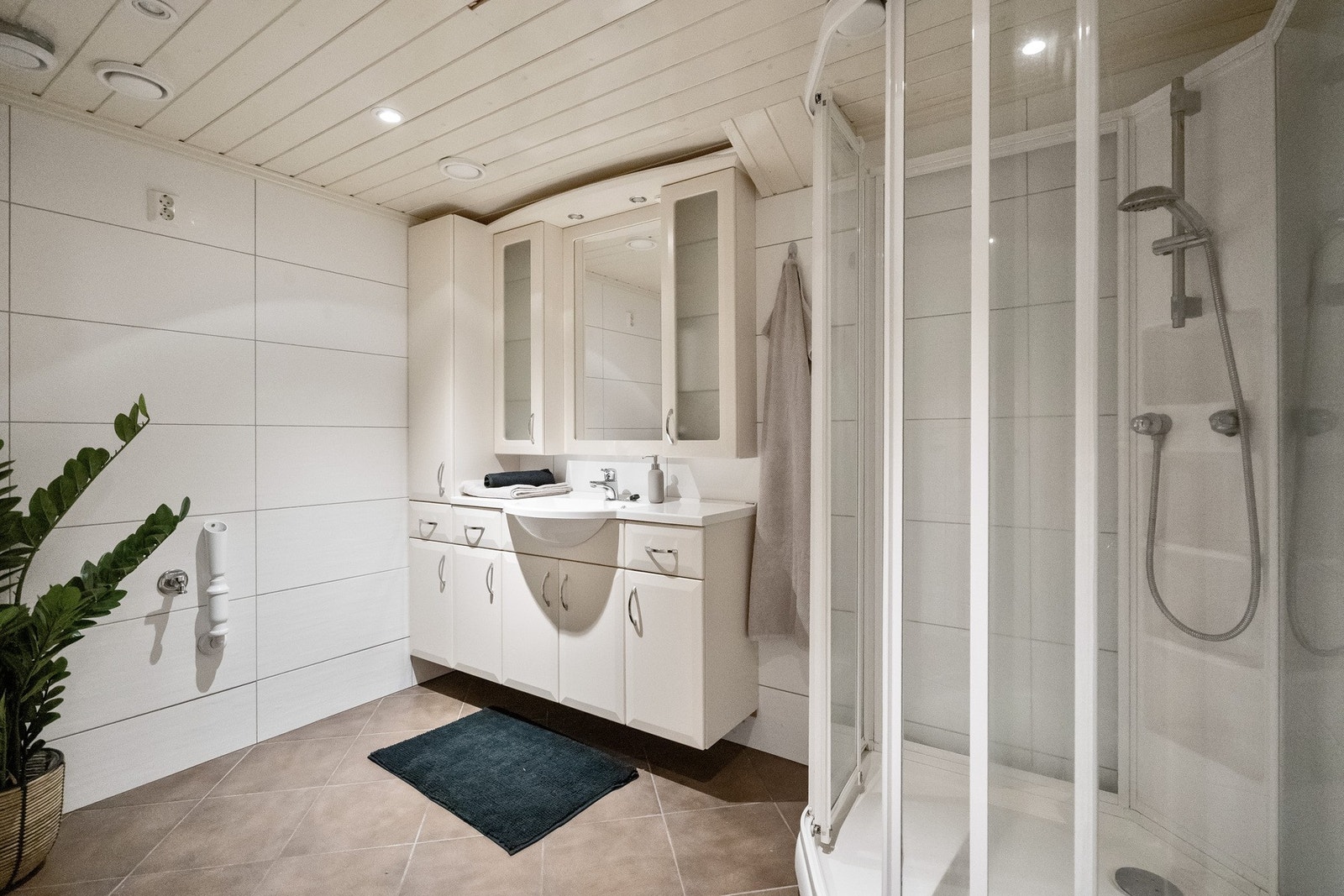 Badet har opplegg for vaskemaskin samt baderomsinnredning og dusjkabinett. Galleribilde