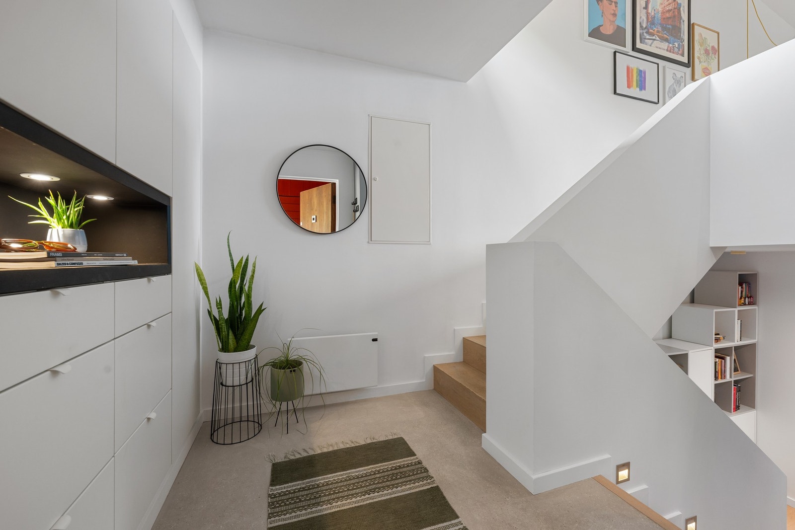 Trappen er pent integrert i boligens flerplansløsning, med lune tretrinn, lyse veggflater og diskret belysning som gir et moderne og gjennomført uttrykk. Galleribilde