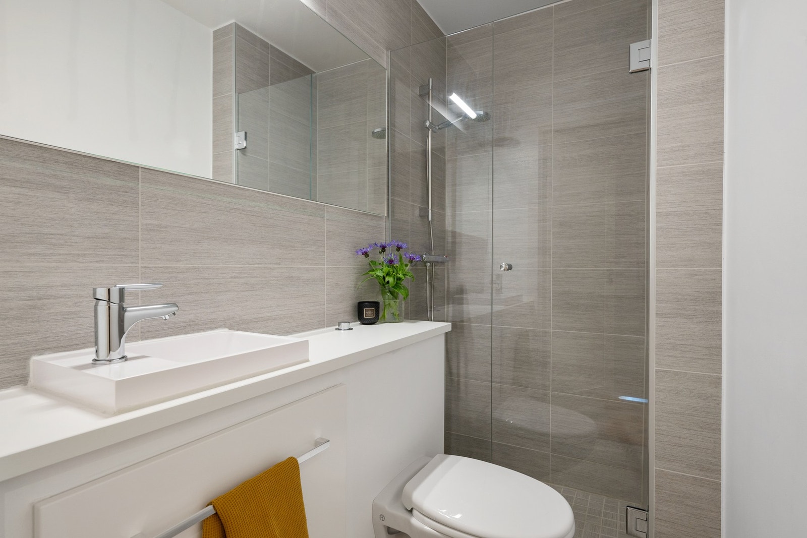 Badet er fra 2014 og holder en god standard, og er innredet med servantskap med glatte, folierte fronter, nedfelt servant, speil og lysarmatur over servant. Galleribilde