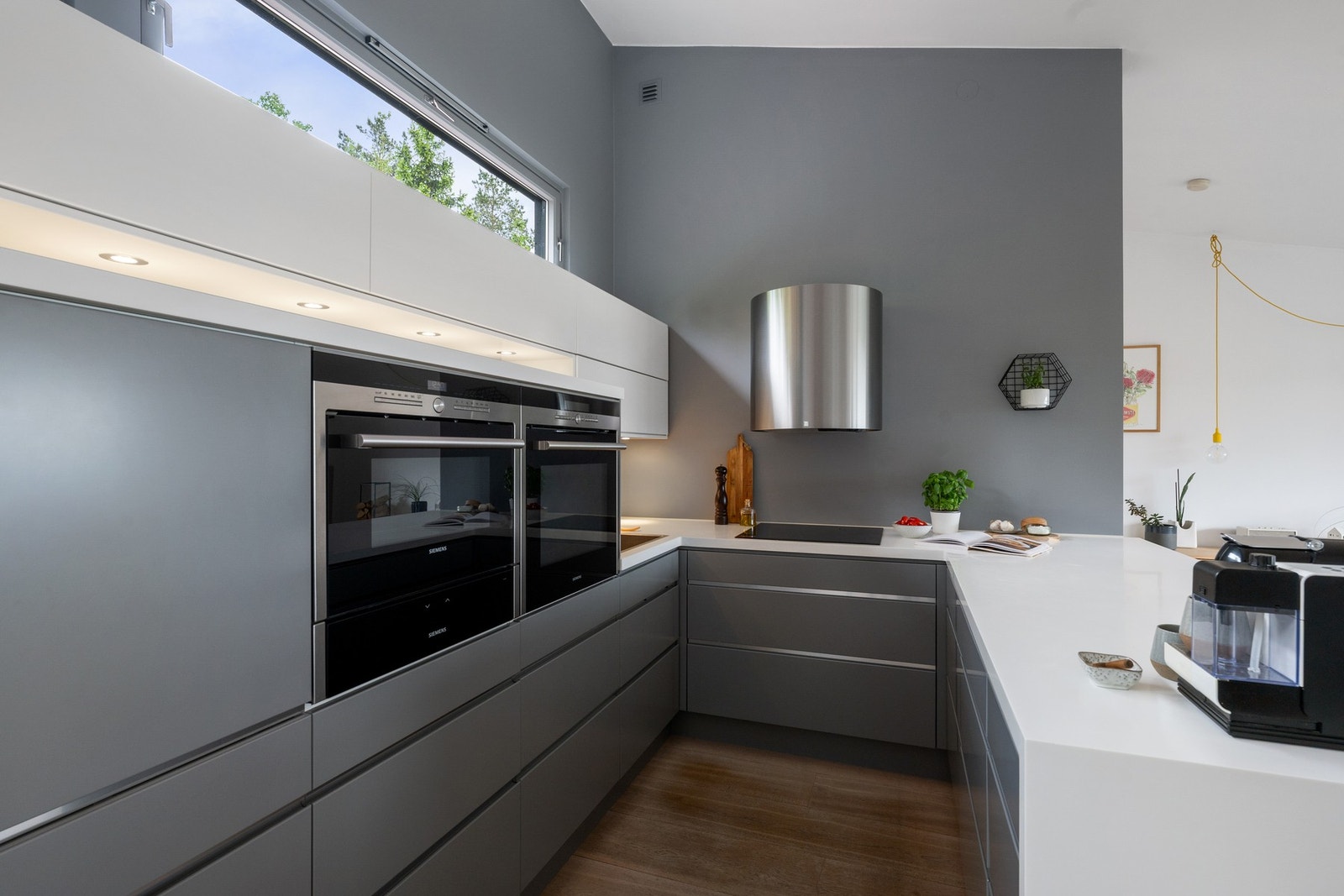 Kjøkkenet er innredet med glatte, fabrikklakkerte fronter og benkeplate med planlimt kum i rustfritt stål. Innredningen er fra 2014, og kjøkkenet har opplegg for platetopp, stekeovn, oppvaskmaskin og kombiskap. Galleribilde