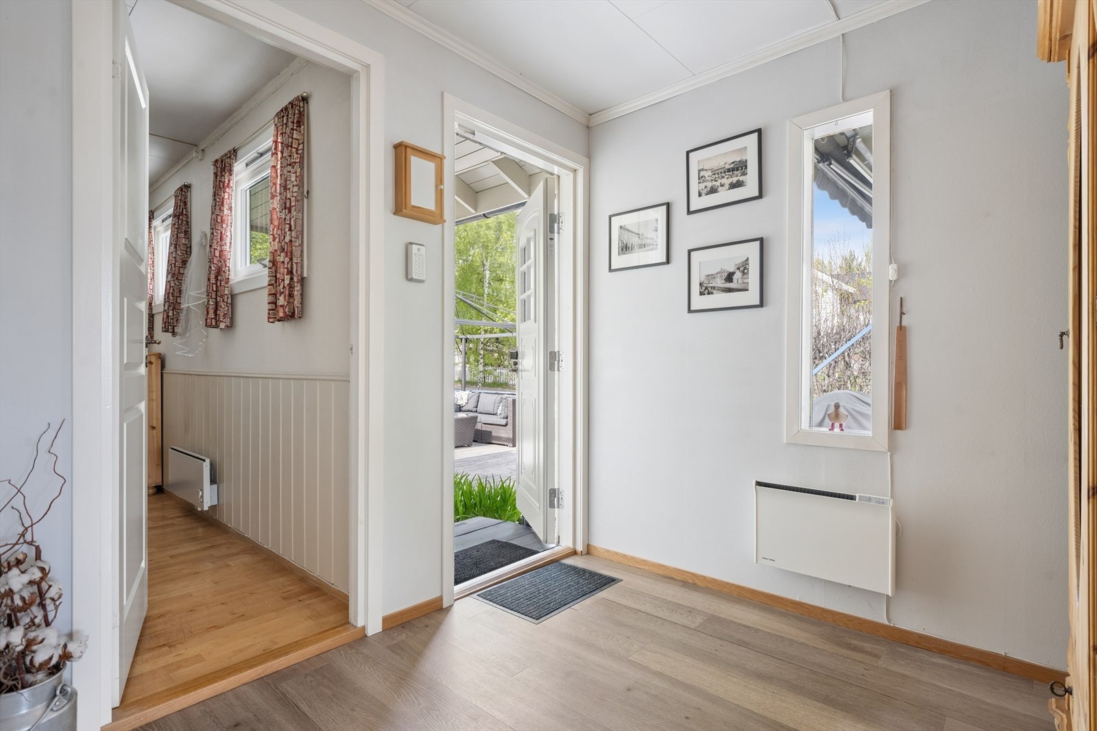 Entréen gir adkomst til boligens oppholdsrom og har en malt ytterdør i tre med isolerglass fra 2011. Galleribilde