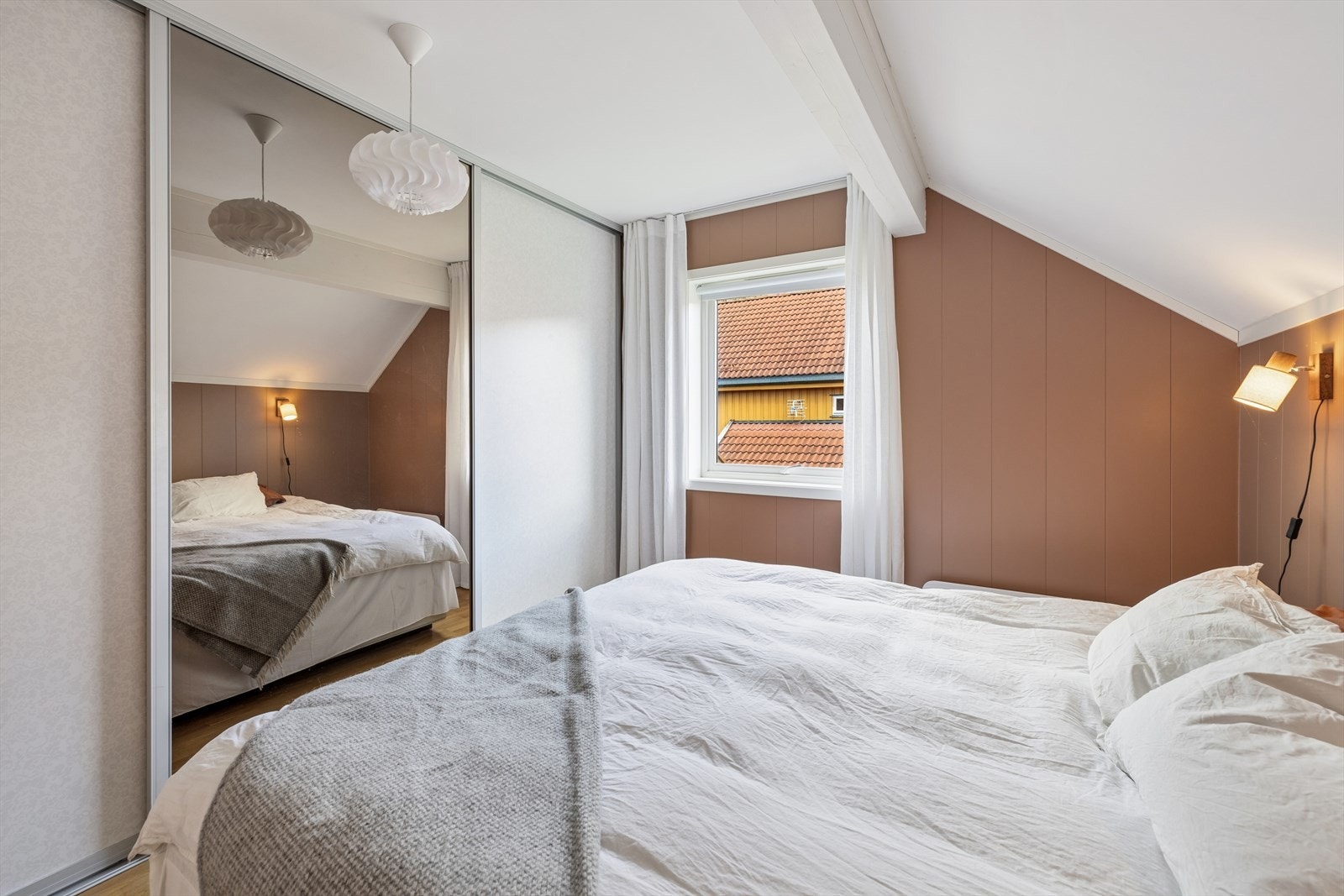 En romslig skyvedørsgarderobe med speilfronter gir rikelig med oppbevaringsplass. Galleribilde