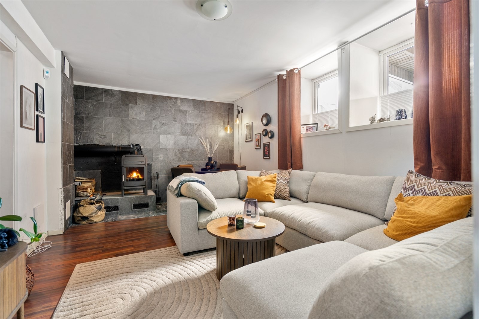 Lys og lun kjellerstue med vedfyring, plass til både sofa og spisebord. Galleribilde