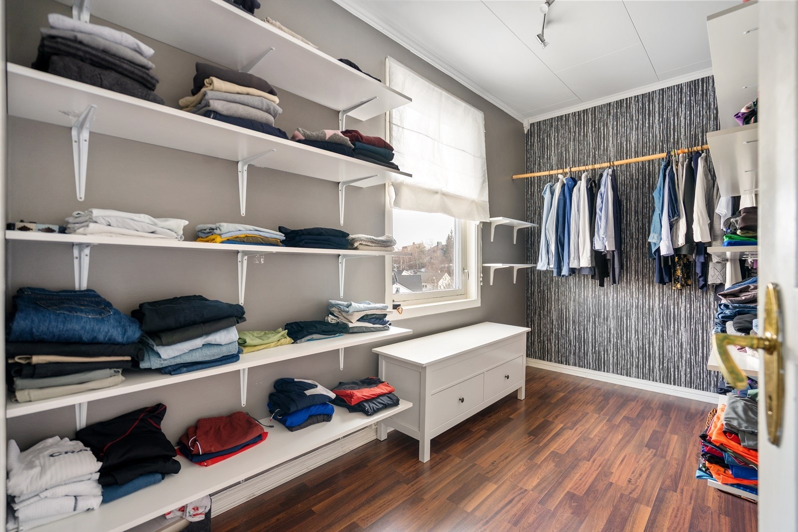 Stort walk-in-closet, med fastmoterte hyller og oppheng. Galleribilde