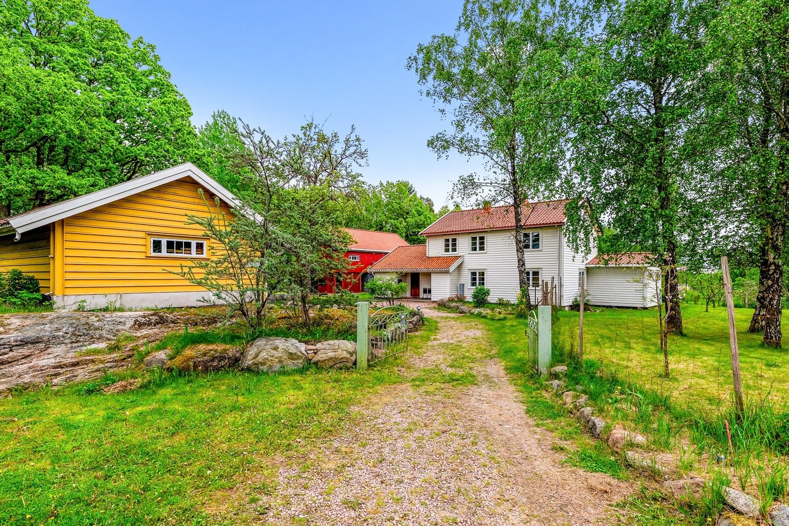 Eiendommen består av tre bygninger: enebolig, uthus/låve og et gult redskapshus. Galleribilde