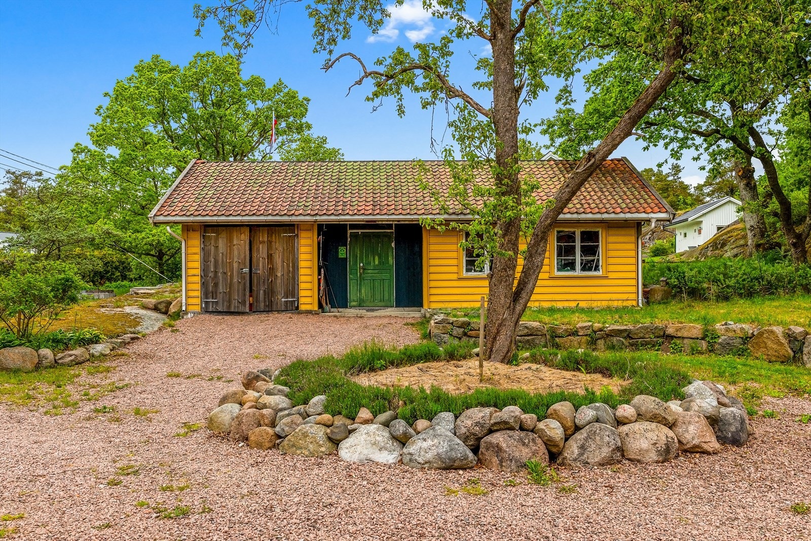 Redskapshuset er på 61 m² og er bygget med gjenbrukte materialer som vinduer og takstein. Galleribilde