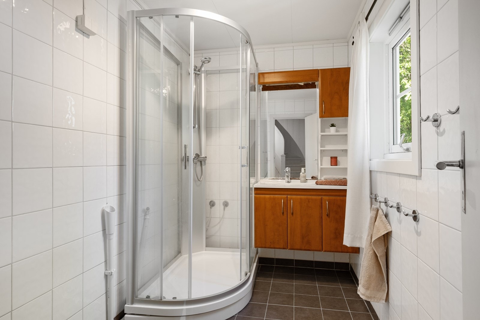 Badet har flislagte overflater og er praktisk innredet. Galleribilde