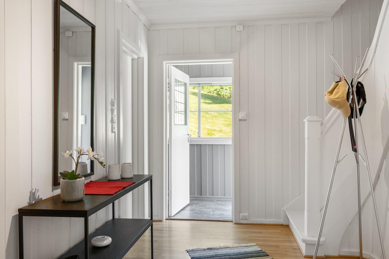 Entréen har panel på veggene og trappeforbindelse til de øvrige etasjene. Galleribilde