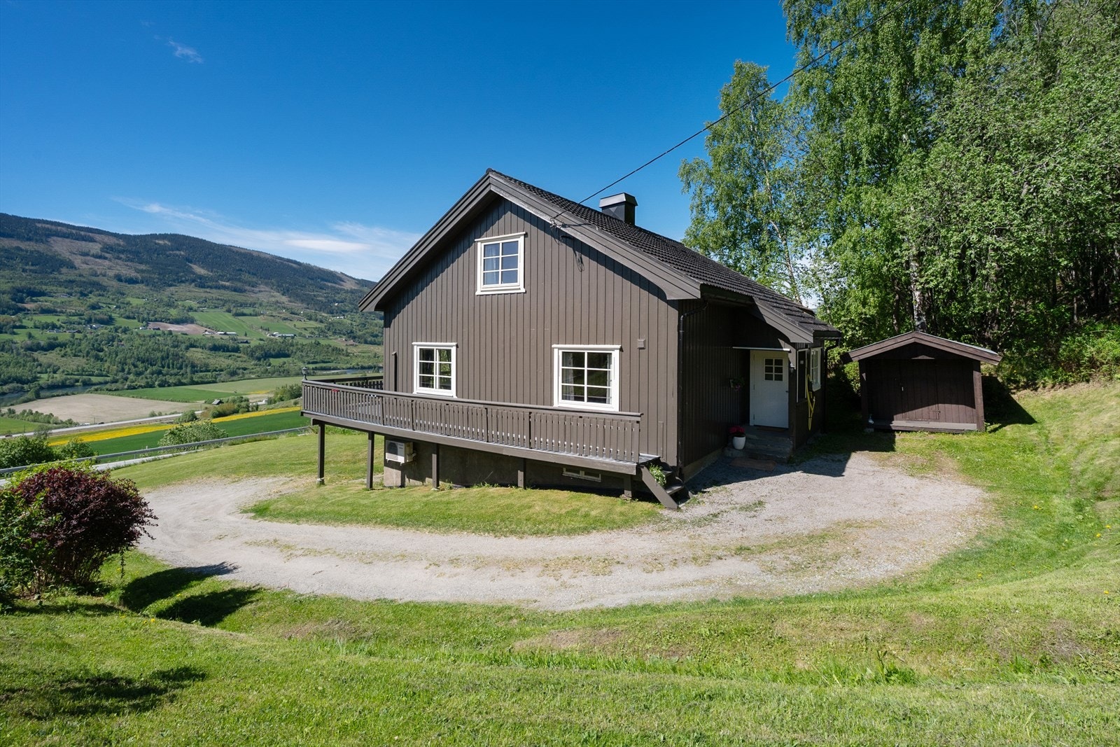 Eiendommen har en flat til skrånende tomt, og gruset adkomst og gårdsplass. Galleribilde