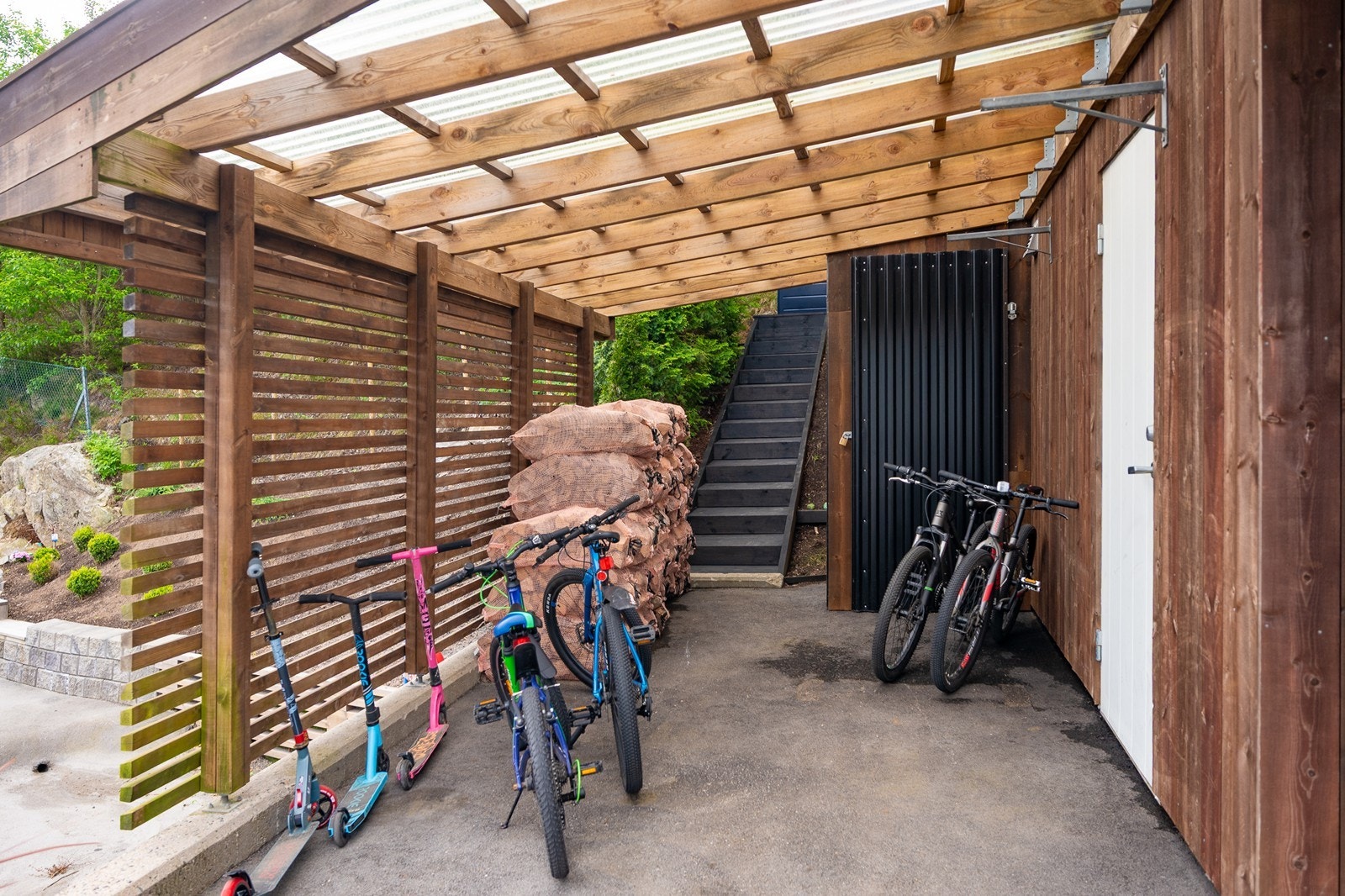 Carport for sykler, redskapsbod og trapp opp til bakhage Galleribilde