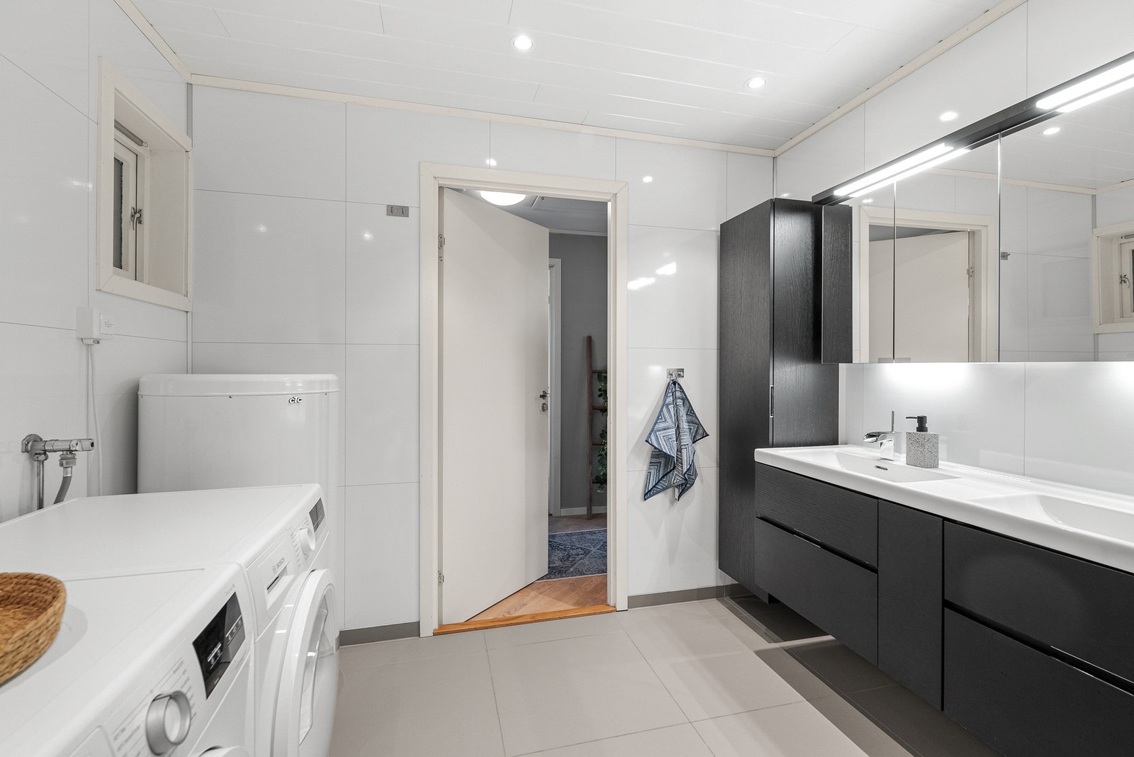 Badet har opplegg for vaskemaskin og tørketrommel, samt godt med oppbevaringsplass i høyskap. Galleribilde