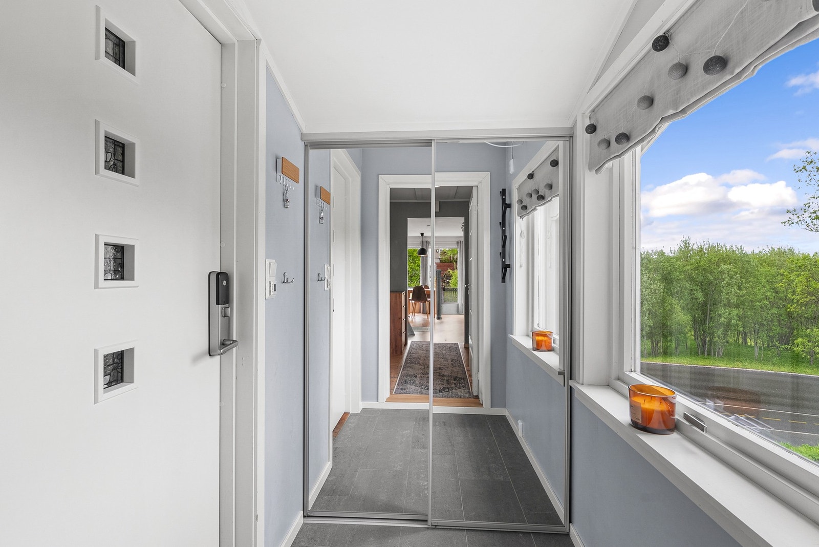 Entréen har flislagt gulv og en stor skyvedørsgarderobe med speilfronter, som gir rikelig med oppbevaringsplass for yttertøy. Galleribilde