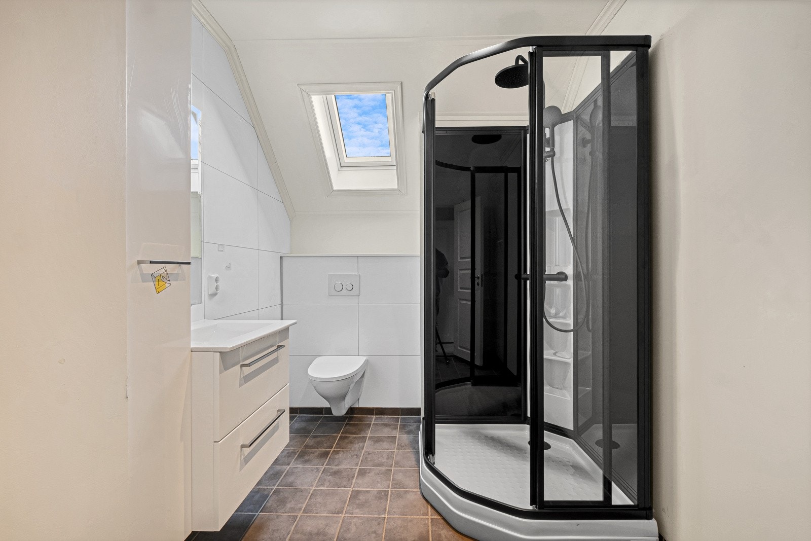 Badet ligger i boligens 2. etasje og har baderomsplater på veggene og flislagt gulv med elektriske varmekabler. Innredning og dusjkabinett nytt i 2026. Galleribilde