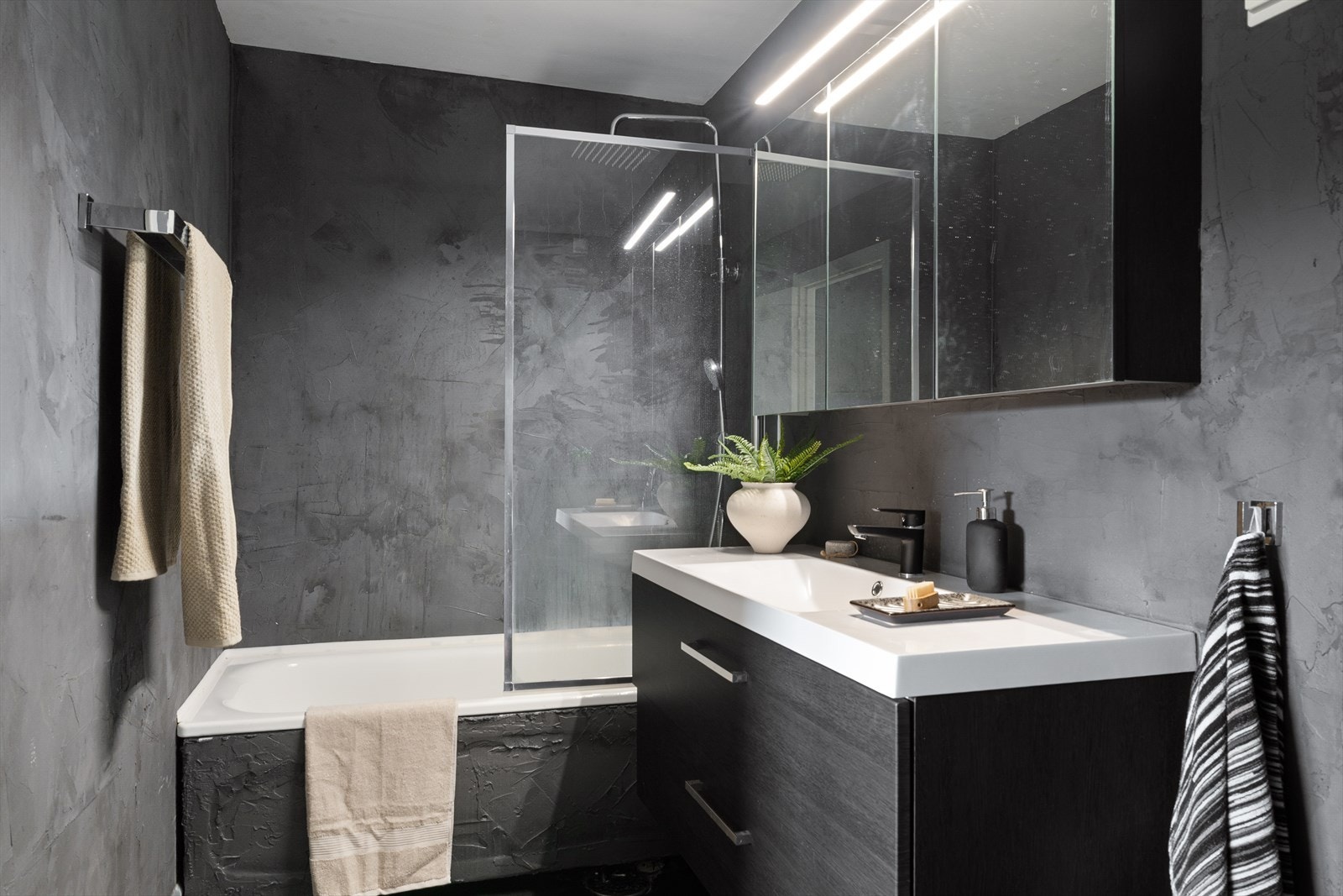 - Badet ble oppusset i 2018 og er overflatebehandlet med microsement. Badet er utstyrt med speilskap, servant med underskap og badekar med regndusj - Galleribilde
