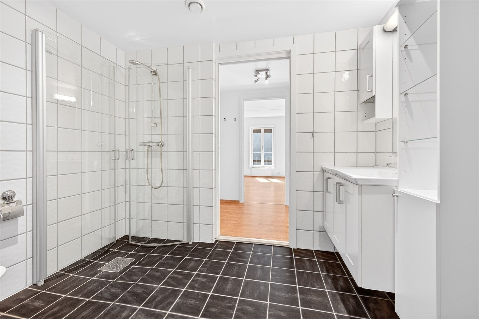 Badet er innredet med dusjhjørne med innfellbare vegger og vegghengt toalett. Galleribilde
