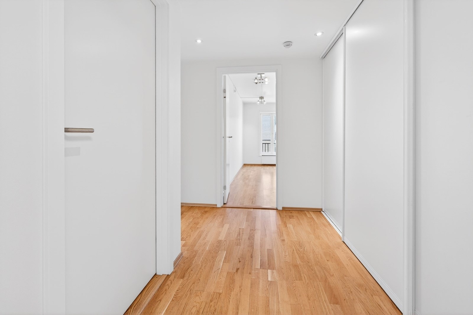 Romslig entré med skyvedørsgarderobe for effektiv oppbevaring av yttertøy. Galleribilde