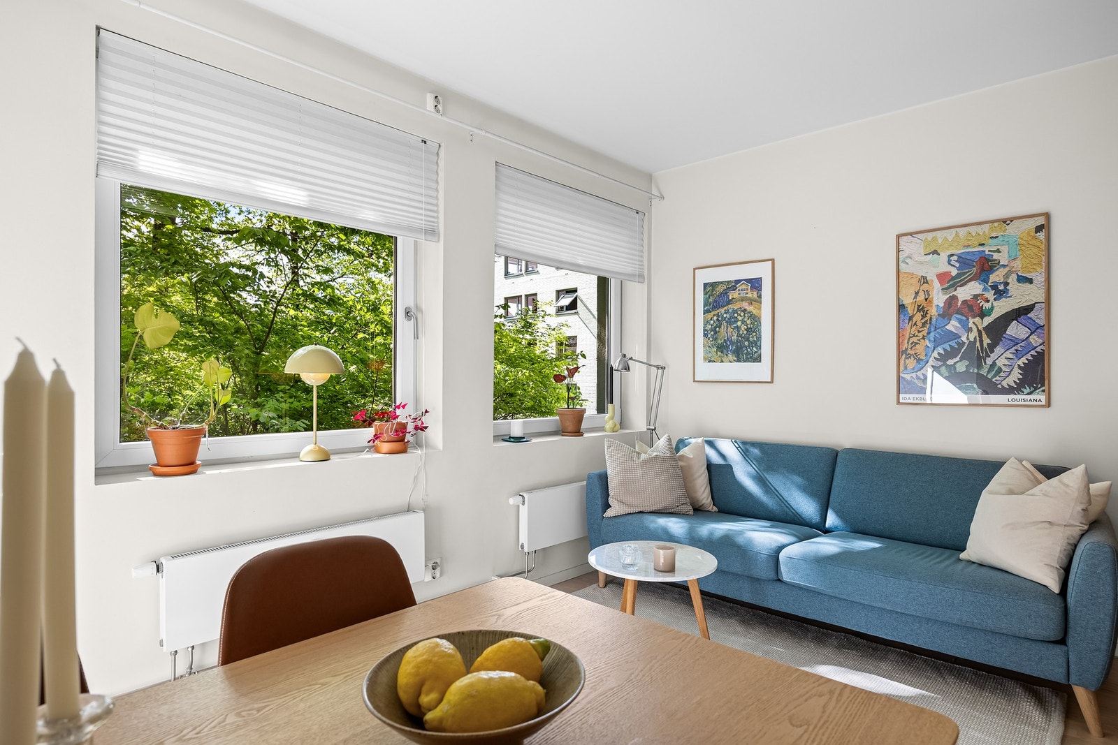 Stuen er et lyst oppholdsrom med store vindusflater (vinduer fra 2010) som vender ut mot et frodig grøntareal. Galleribilde