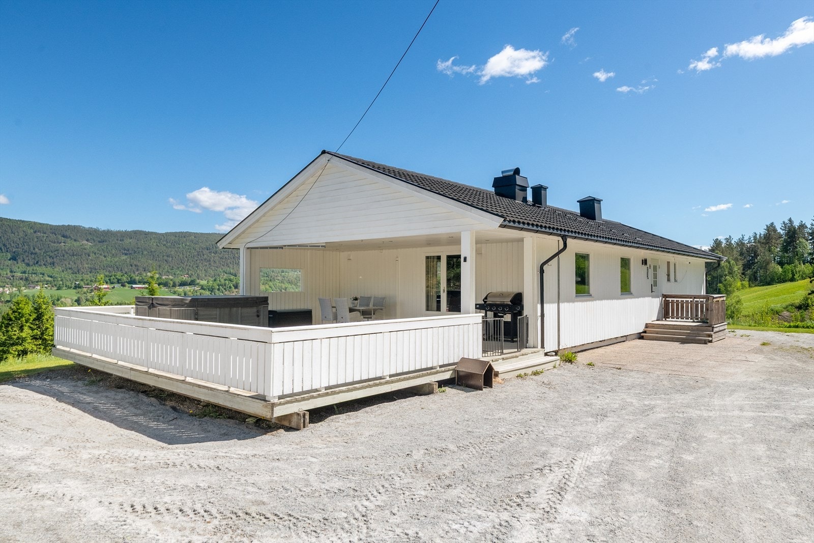 Eiendommen har en stor, gruset gårdsplass med rikelig med parkeringsplass. Galleribilde