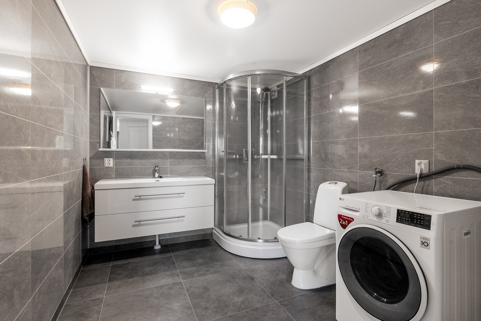 Badet i leiligheten er flislagt, har elektriske varmekabler og opplegg for vaskemaskin. Galleribilde