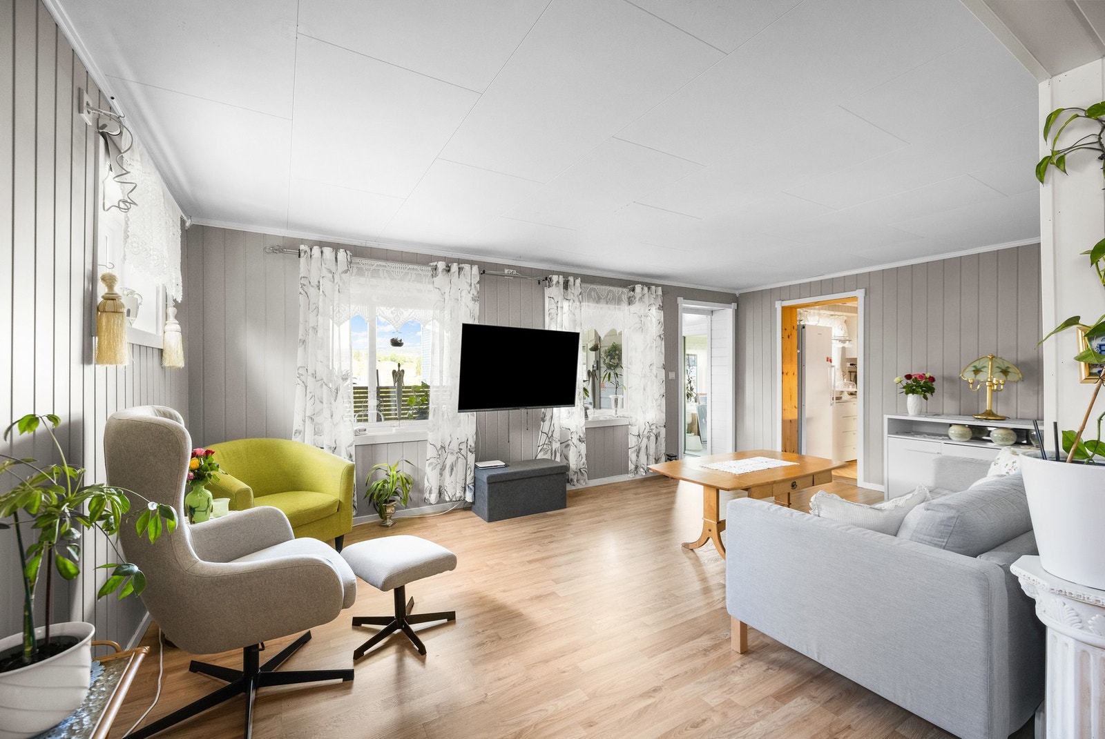 Rommet er innredet som stue, med store vindusflater og gulvflater av laminat. Galleribilde