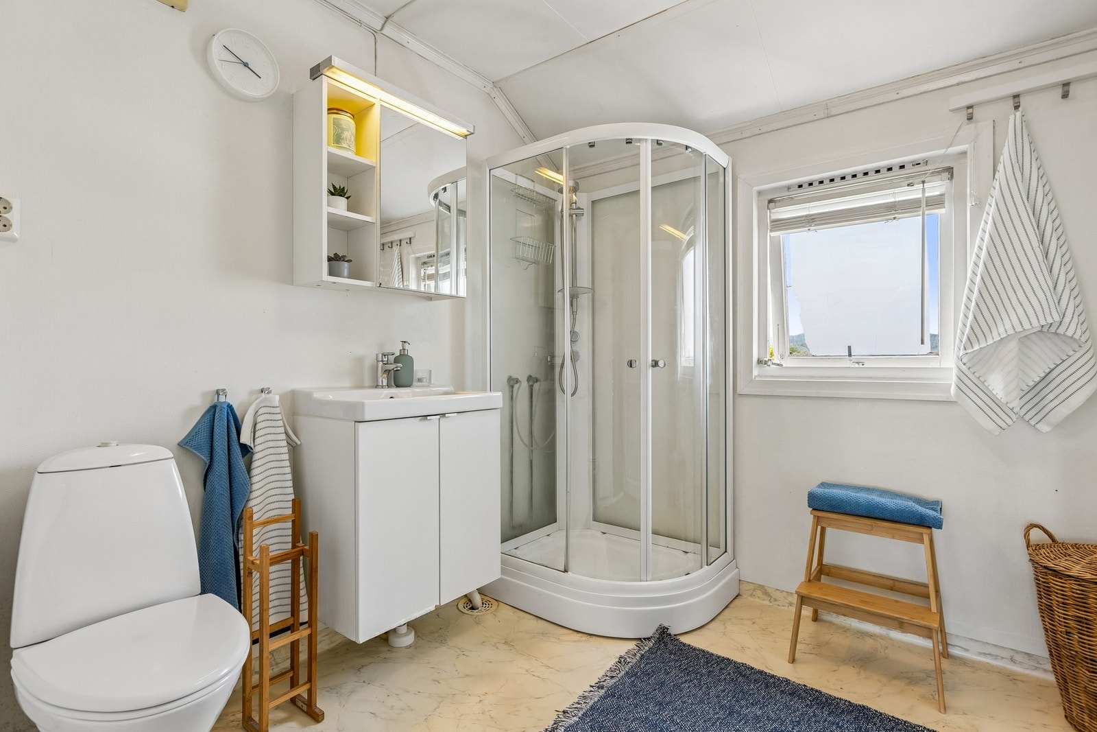 Badet i andre etasje er innredet med vegghengt servantinnredning, speilskap med belysning, dusjkabinett og toalett. Galleribilde