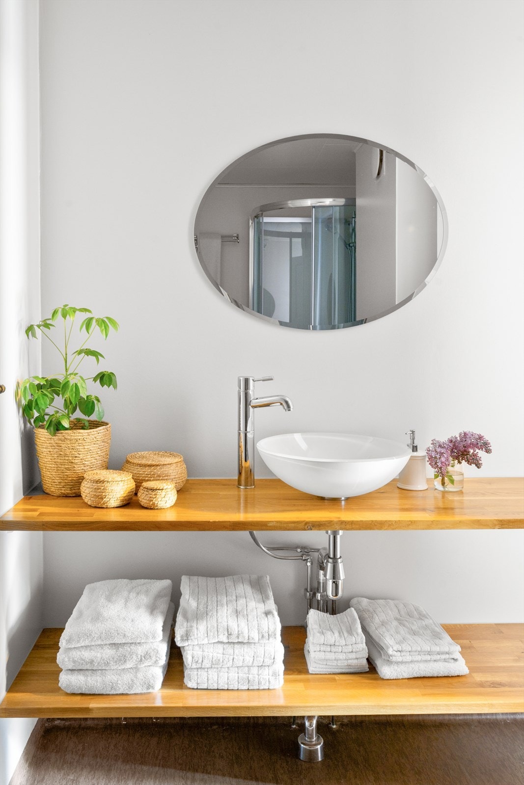 Badet har glasservant på benkeplate, speil og belysning. Galleribilde