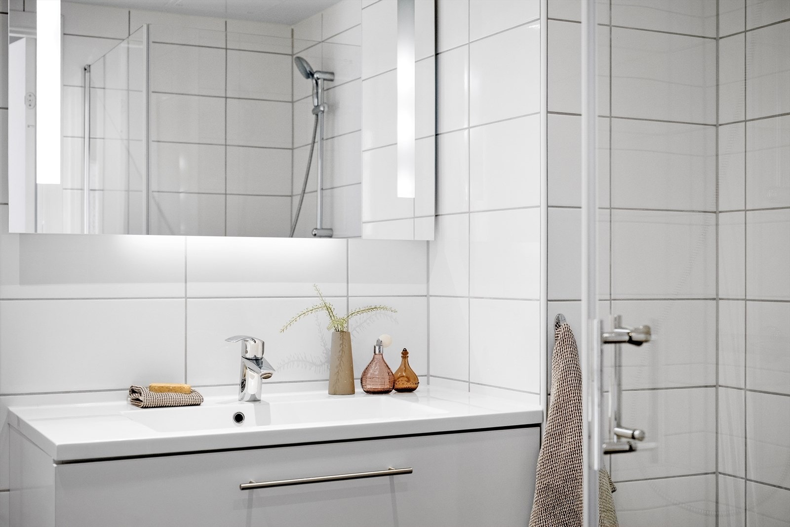 Detalj fra badet, med servant og speilskap med belysning. Galleribilde