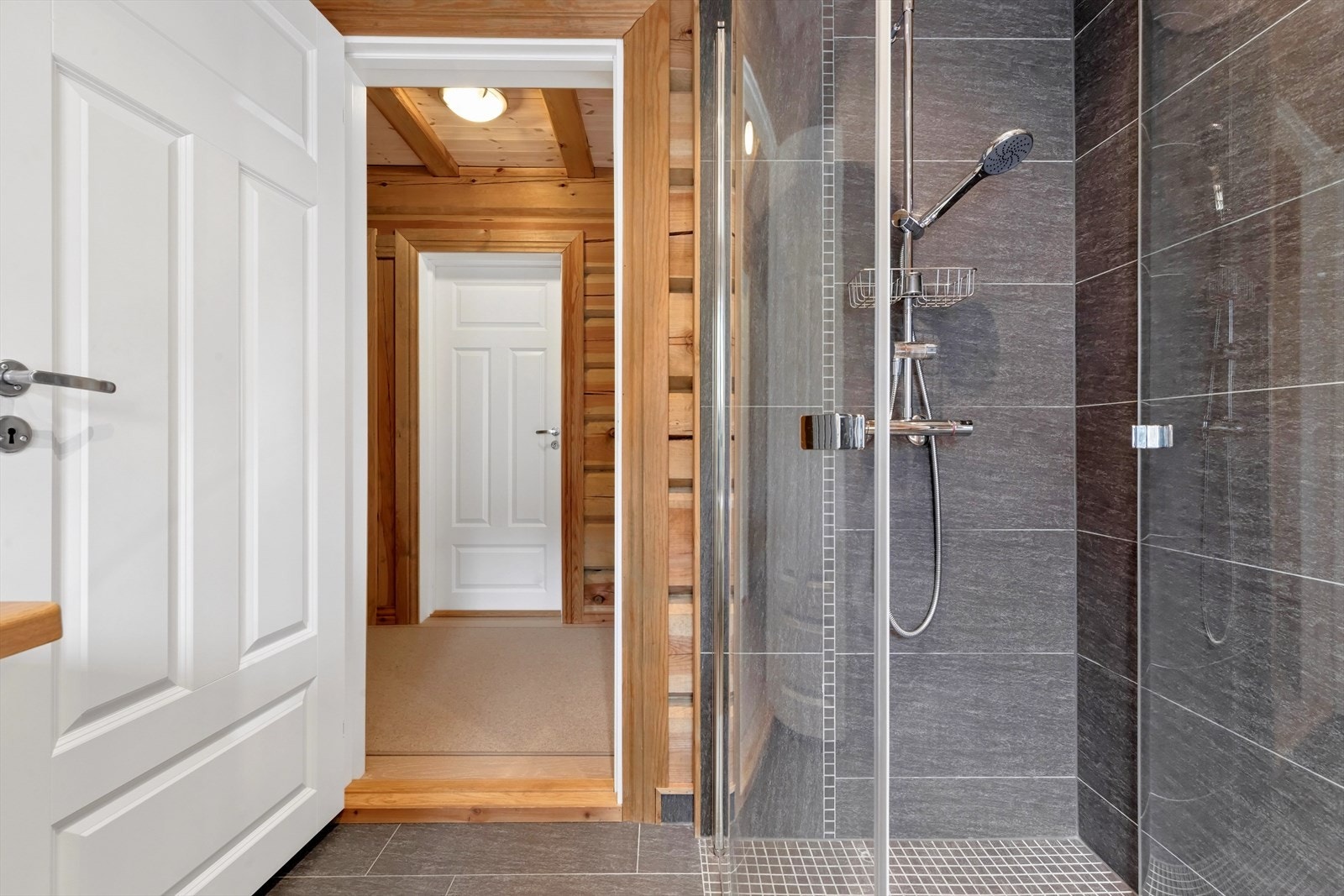 Badet er utstyrt med badekar, dusjløsning, servant og toalett. Galleribilde