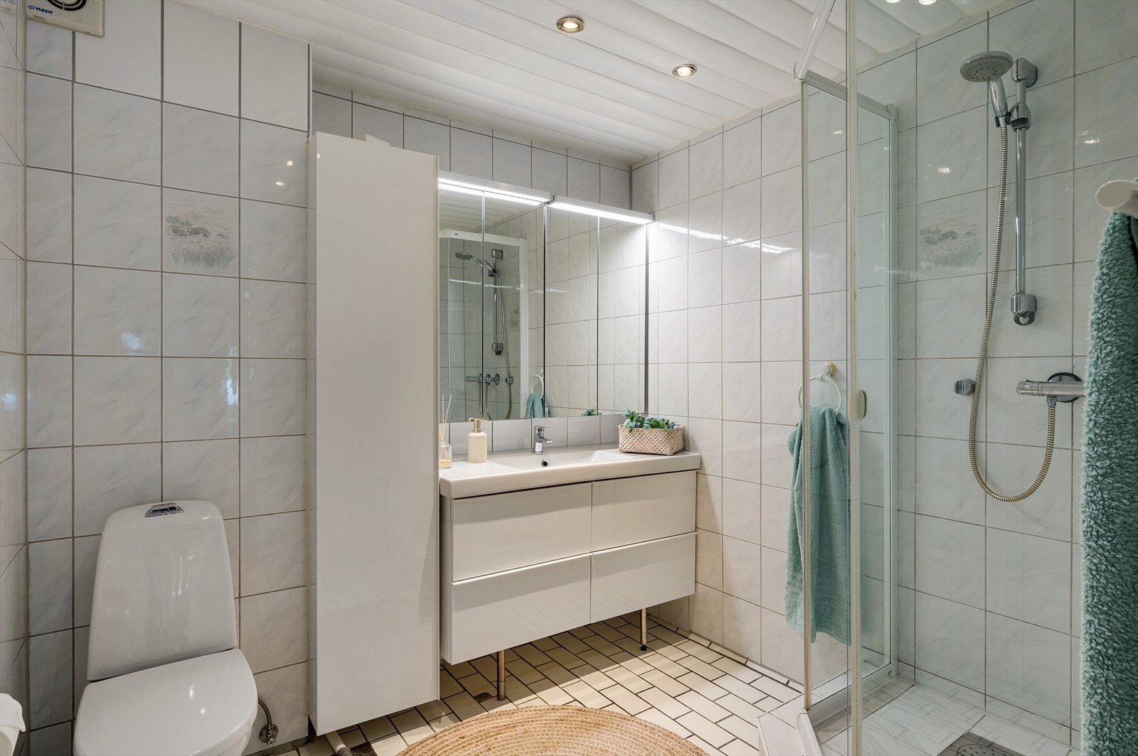- Badet er innredet med dusjhjørne, toalett, servant med møblement, høyskap og speil med belysning - Galleribilde