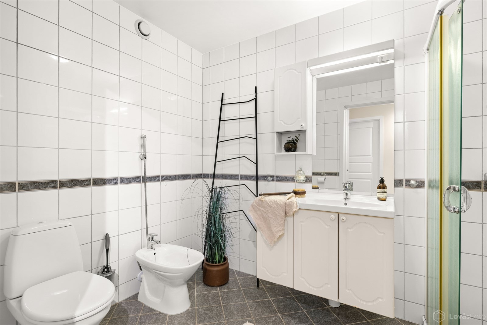 Romslig flislagt bad med funksjonell utforming. Galleribilde