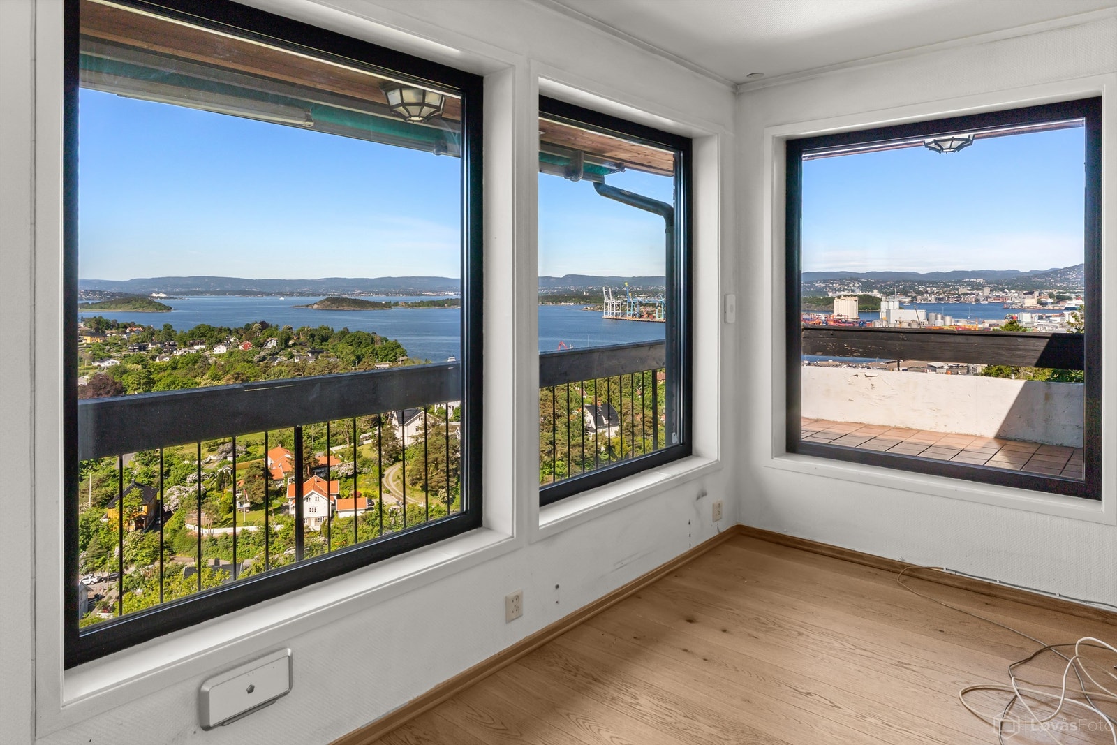 Balkongen har flislagt gulv og rekkverk i tre, metall og mur. Galleribilde