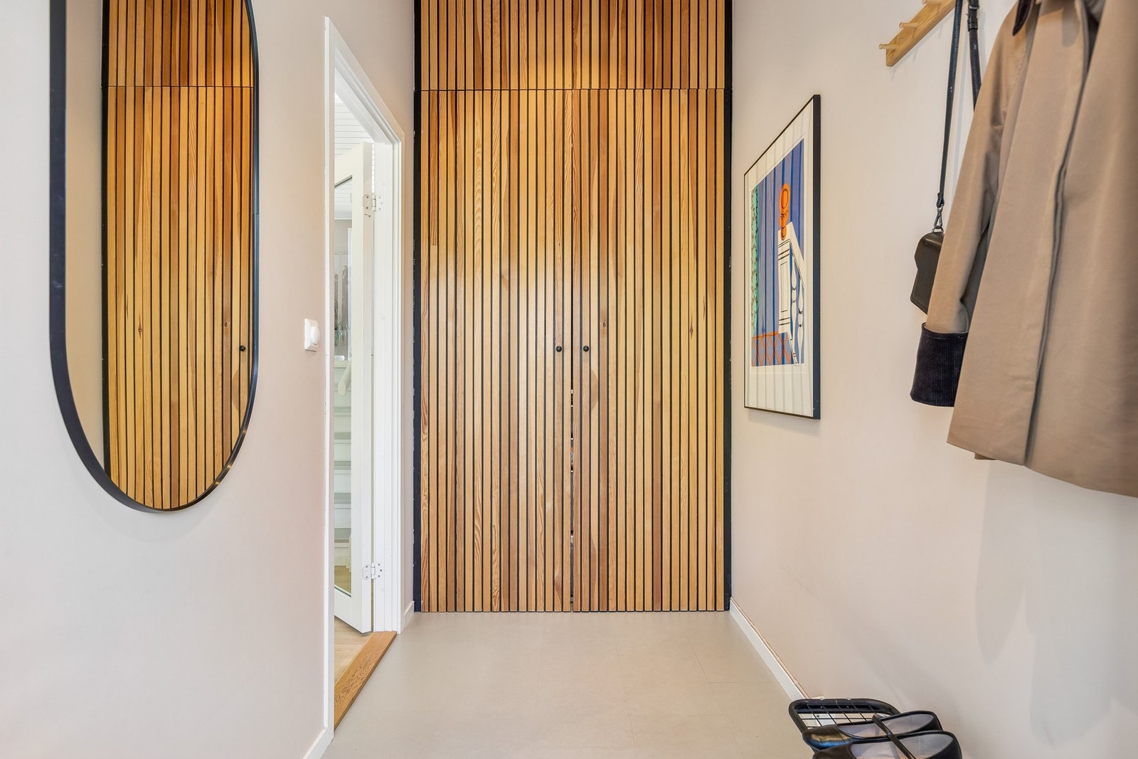 Velkommen inn! Vindfanget har god plass til å henge fra seg klær og sko. Det plassbygde skapet har muligheter til å både åpne fra vindfanget i tillegg til stua. Galleribilde