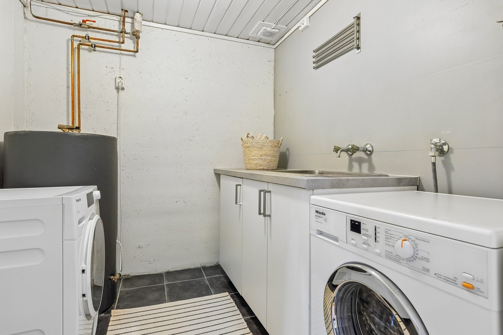 Praktisk vaskerom med kran og avløp til vaskemaskin. Kran og avløp til vaskemaskin, vaskekum og varmtvannstank. Galleribilde