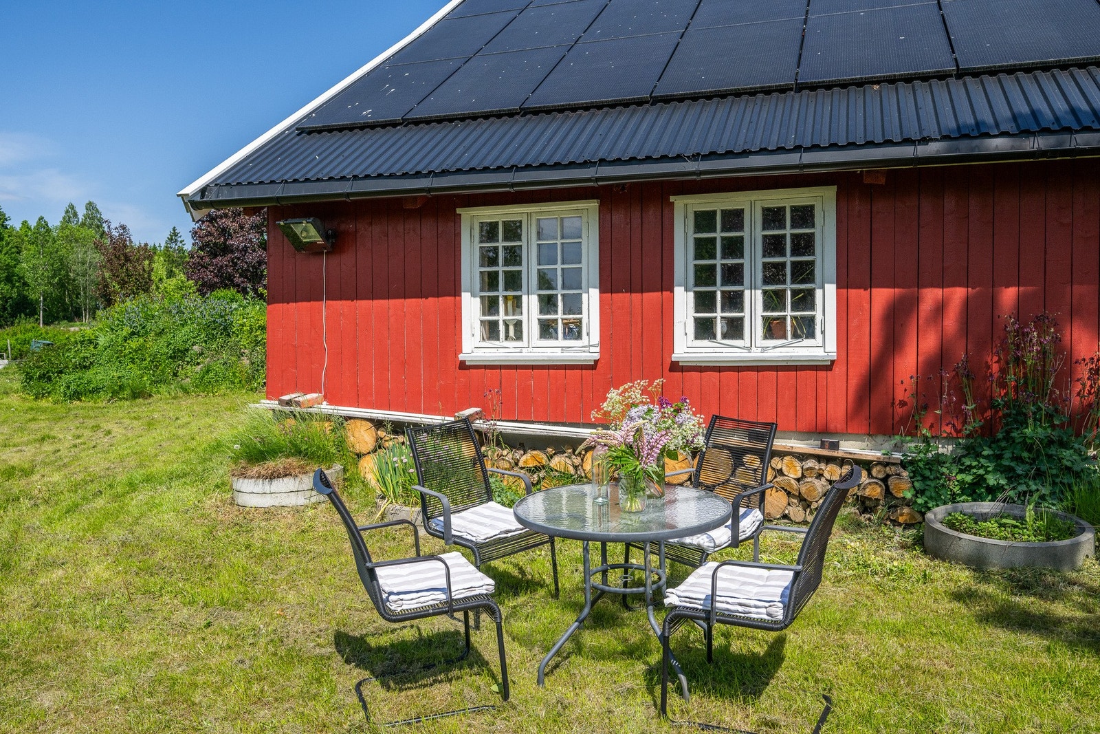 Solrike uteplasser inviterer til lange sommerdager i landlige omgivelser. Her er det montert 46 solcellepanel på taket til låven som drar nytte av de gode solforholdene Galleribilde