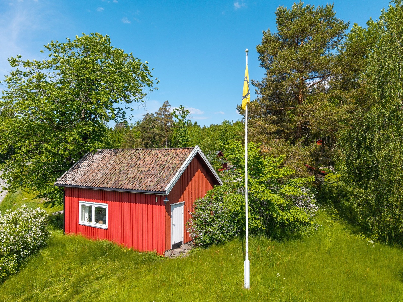 Næringsbygget ligger på egen teig på andre siden av veien og gir ytterligere fleksibilitet og muligheter for virksomhet, hobby eller lagring Galleribilde