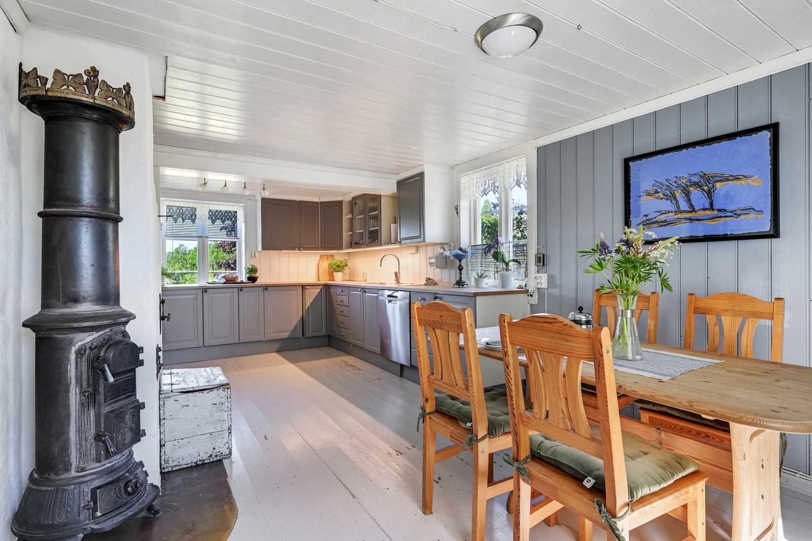 Velkommen inn i boligens kjøkken som byr på en sjarmerende rundovn med utsmykning og sommerfuglkrone Galleribilde