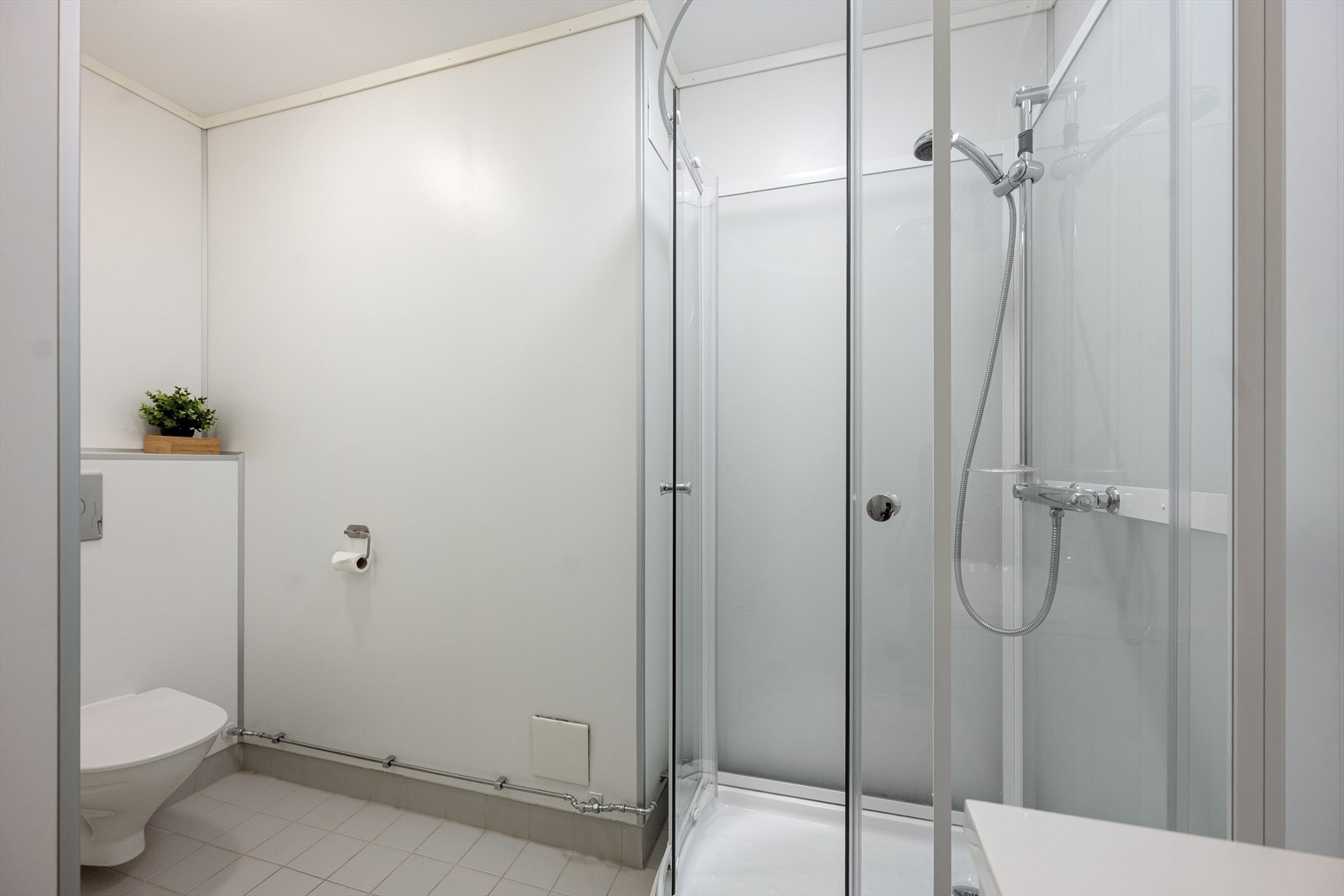 Badet ble oppgradert med baderomsplater på veggene, nye fliser, vegghengt toalett, servantskap og funksjonelt dusjkabinett. Galleribilde