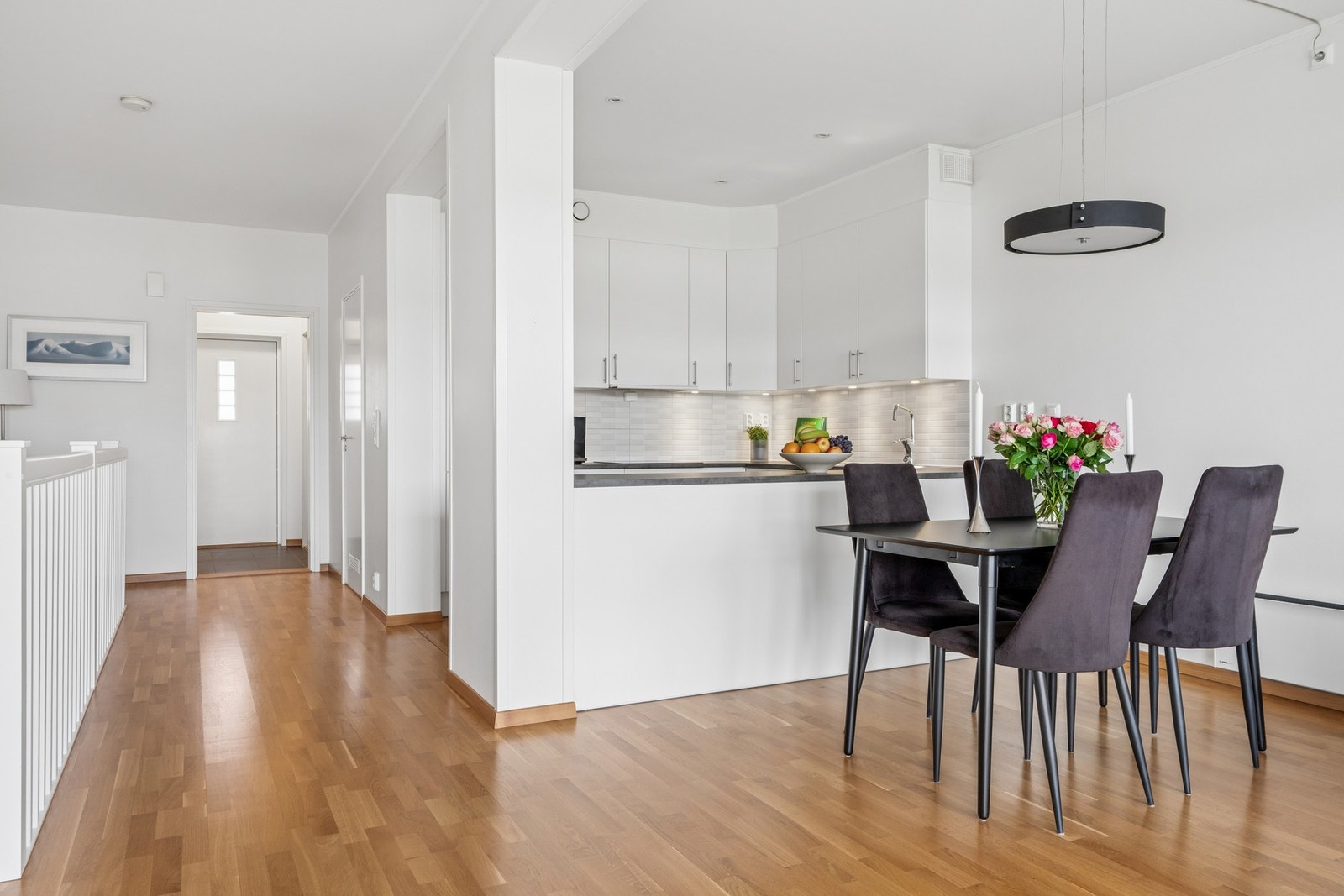 Kjøkkeninnredning med slette fronter og laminert benkeplate. Den åpne barløsningen skaper en naturlig overgang til spiseplassen. Galleribilde