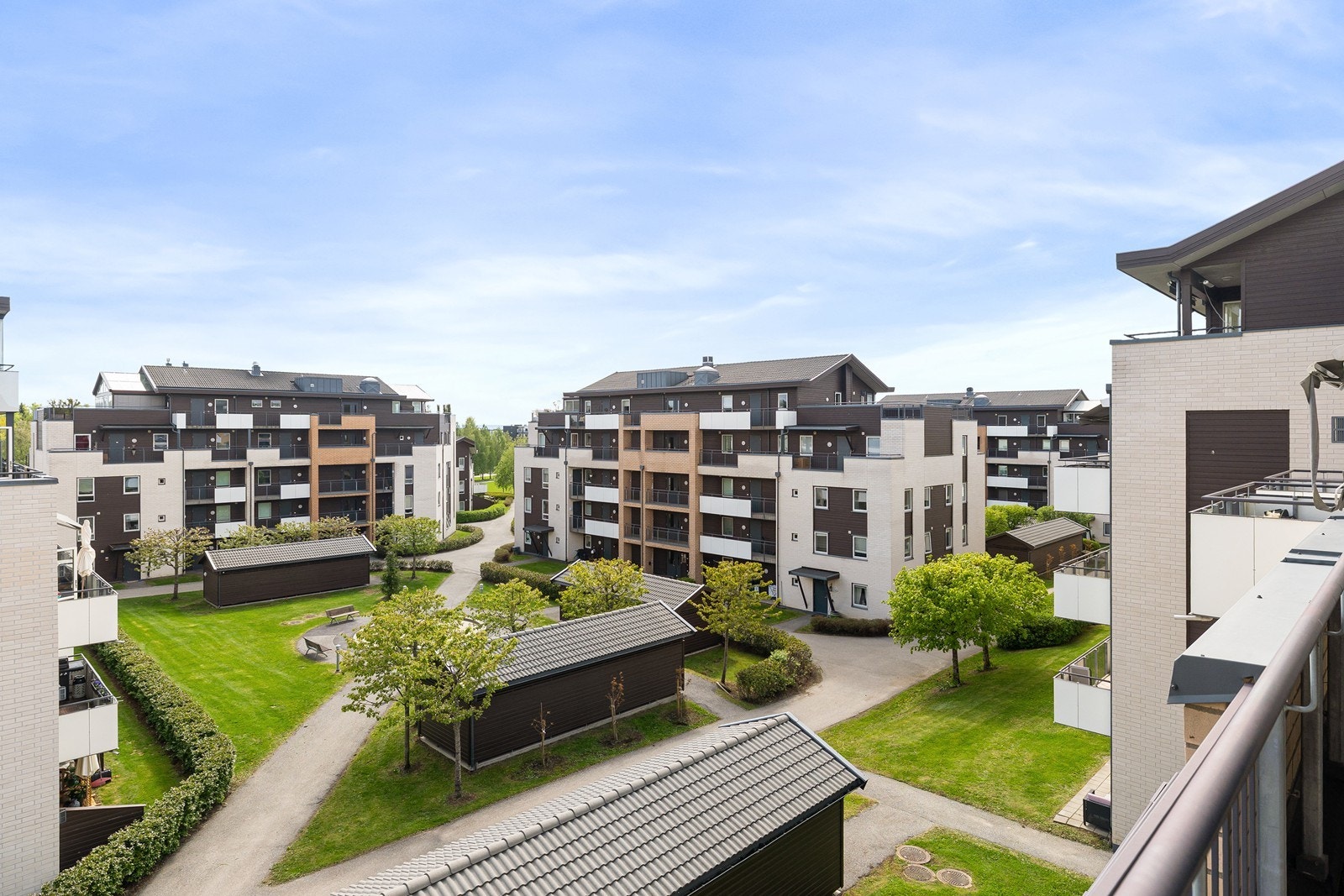 Fint fellesareal mellom boligbyggene med plen, sittegrupper og internveier. Galleribilde