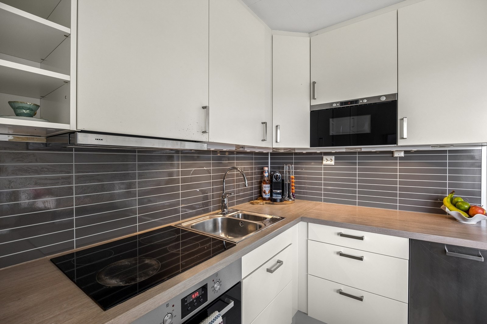 Kjøkkenet har innredning med glatte fronter, foliert benkeplate i heltre og ventilator med avtrekk ut. Galleribilde