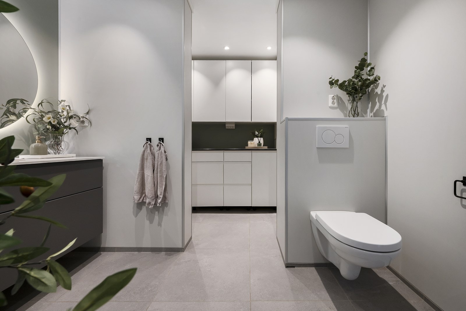 Badet er utstyrt med baderomsmøbel med heldekkende servantplate og speil med bakgrunnsbelysning, vegghengt toalett og dusjhjørne med himmeldusj og innfellbare dører. Galleribilde