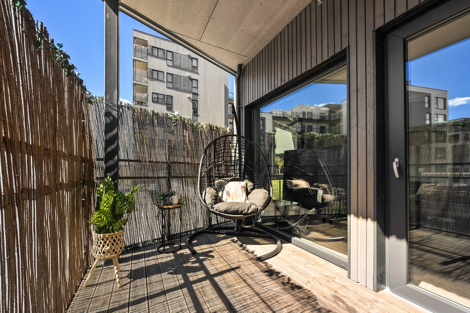 Balkongen er belagt med impregnerte terrassebord og har rekkverk i stål og glass. Galleribilde