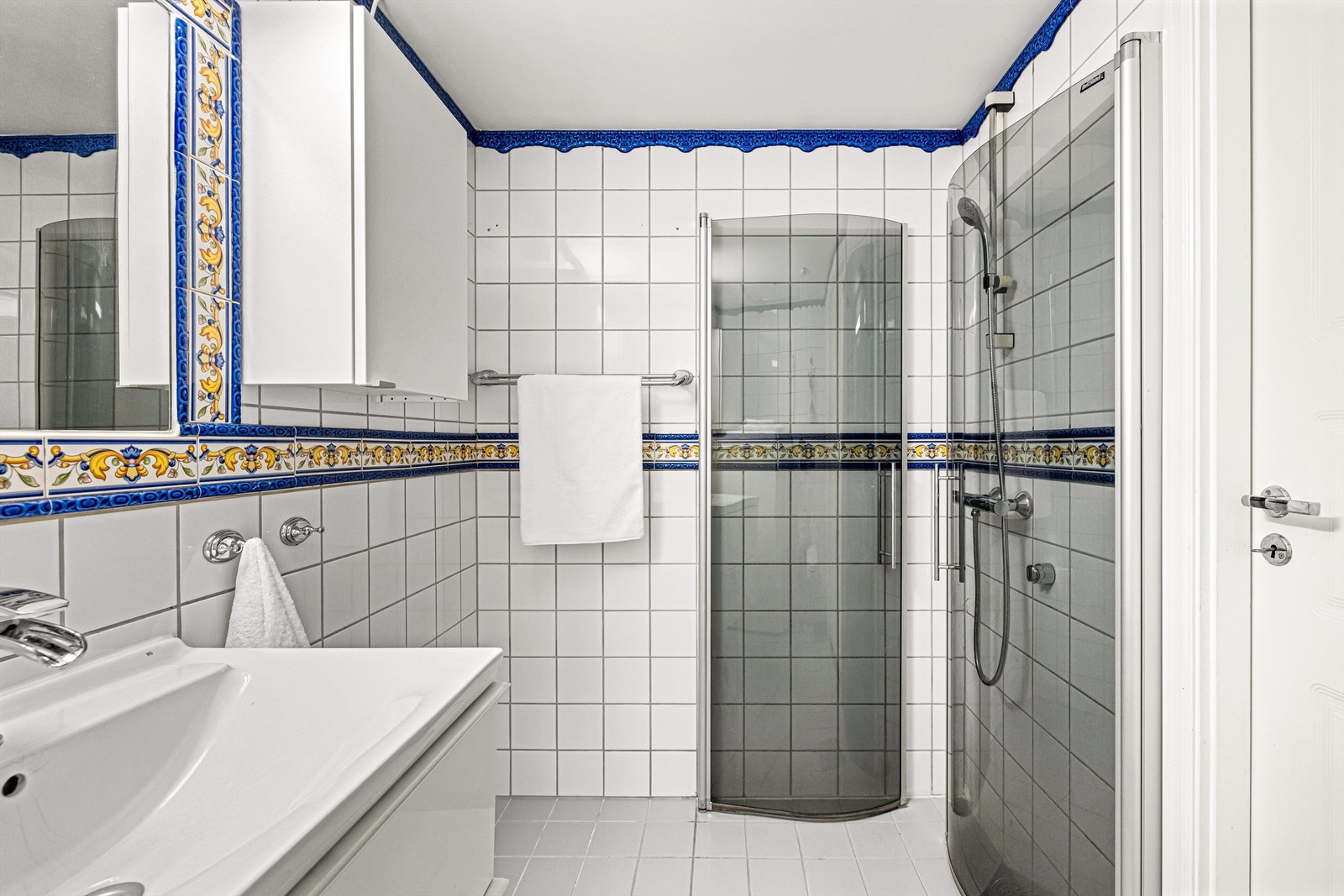 Badet har en praktisk dusjnisje med innfellbare glassdører. Galleribilde