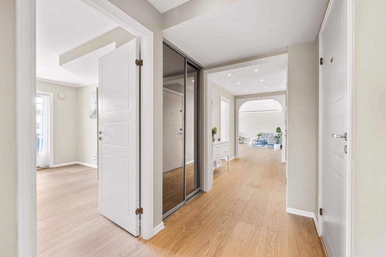 En romslig skyvedørsgarderobe med speilfronter gir rikelig med oppbevaringsplass i gangen. Galleribilde