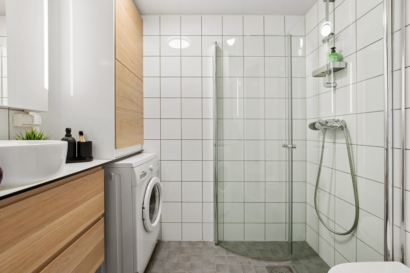 Badet i hoveddelen er flislagt og har elektrisk gulvvarme, vegghengt toalett og opplegg for vaskemaskin. Galleribilde
