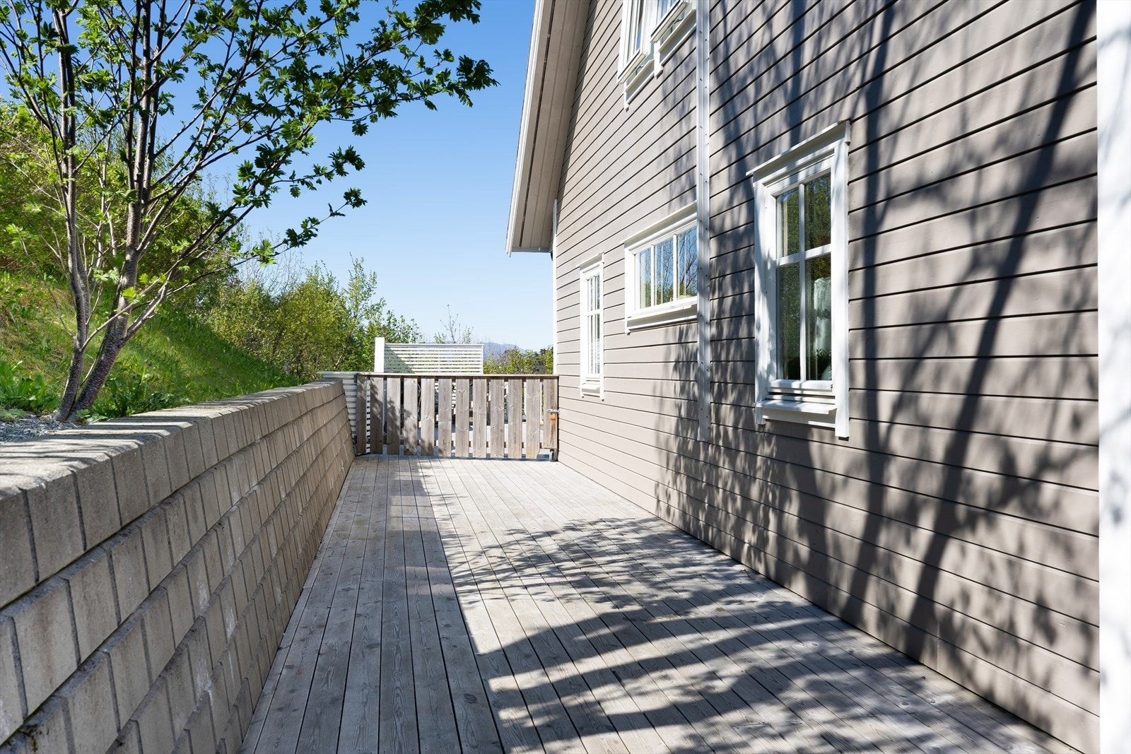 Terrassen mot sør er avgrenset mot eiendomsgrensen med en mur. Galleribilde